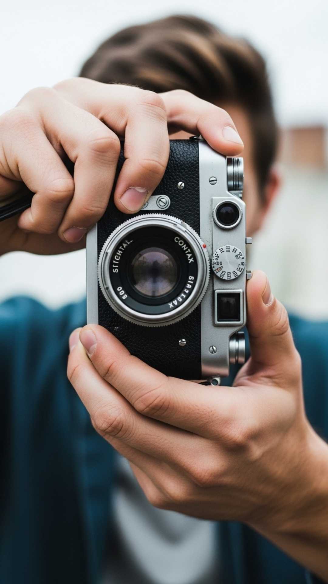 Cool hidden face DP of a boy holding a vintage camera.