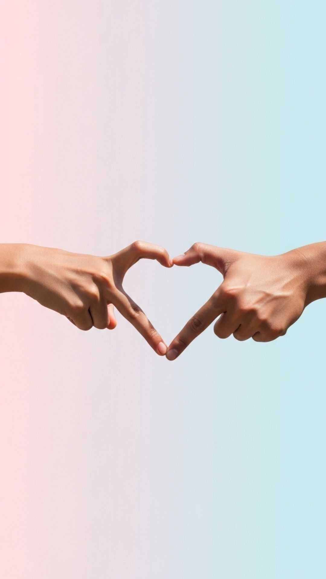 A minimalist photo of a couple's hands forming a heart shape with their fingers against a pastel background.