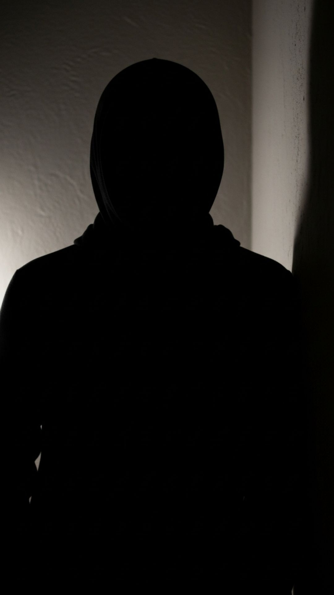 Person's figure lost in deep shadows of a room corner, conveying a sense of withdrawal into darkness. Sad DP, shadow, obscure