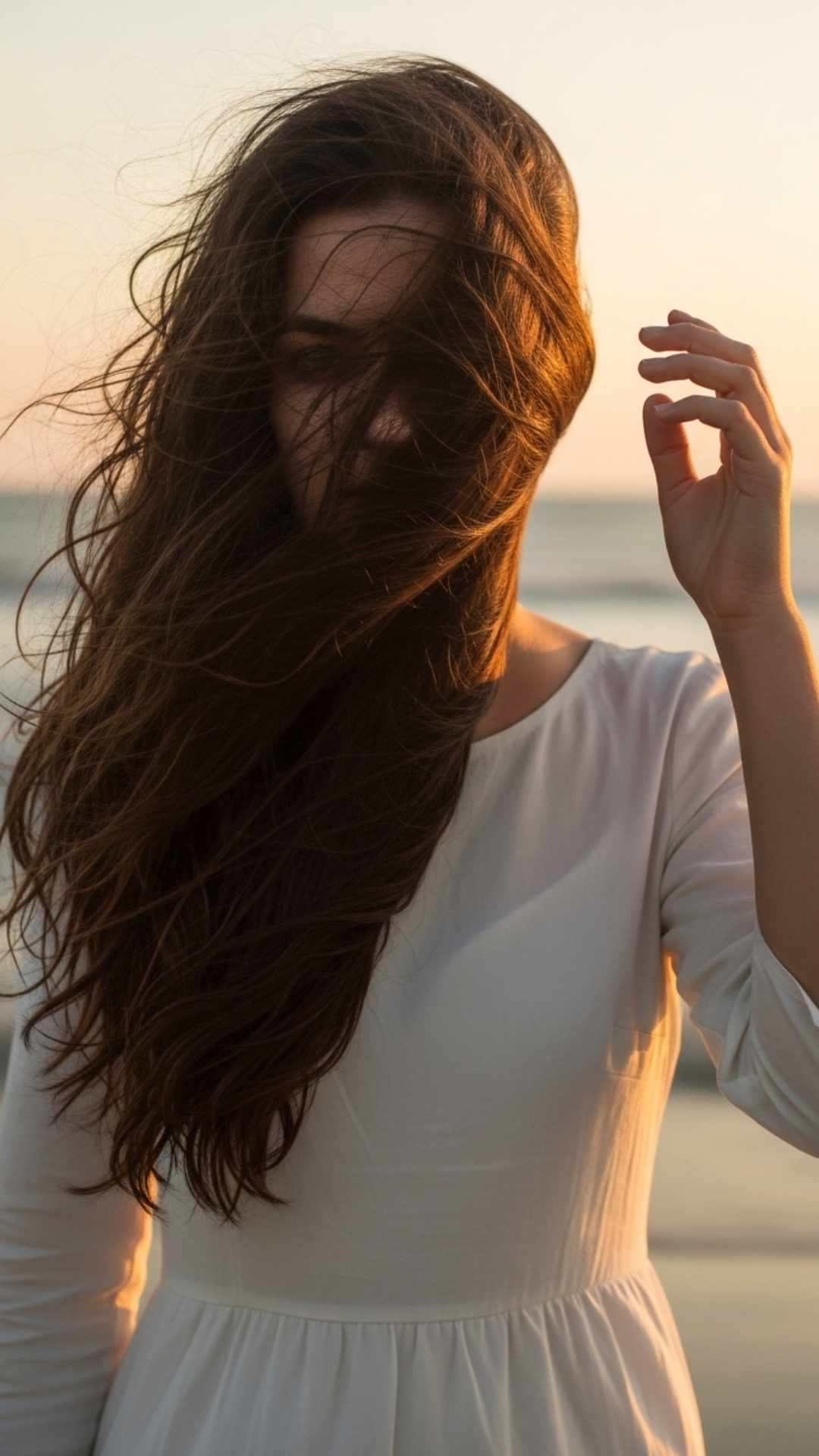 A beautiful hidden face DP of a girl on a beach with her hair blowing in the wind, symbolizing freedom and natural beauty.