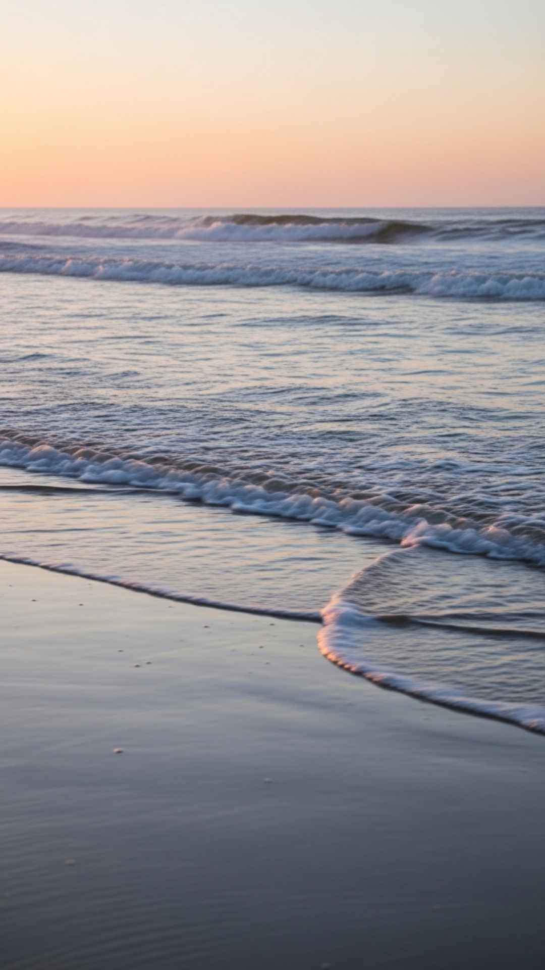 Minimalist Nature DP for WhatsApp showing gentle waves on a sandy beach at sunset, evoking a sense of calm and serenity.