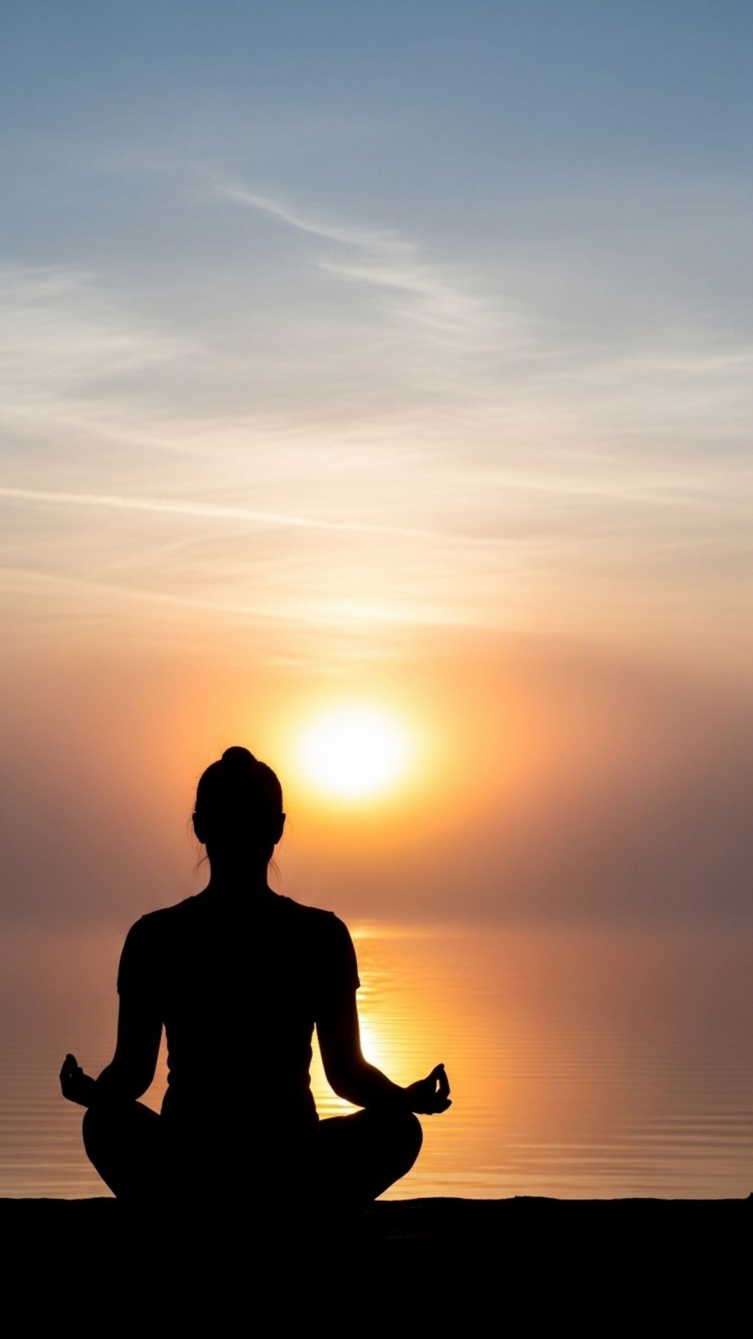 A tranquil silhouette of a person meditating at sunrise over a misty lake, with warm colors reflecting on the water