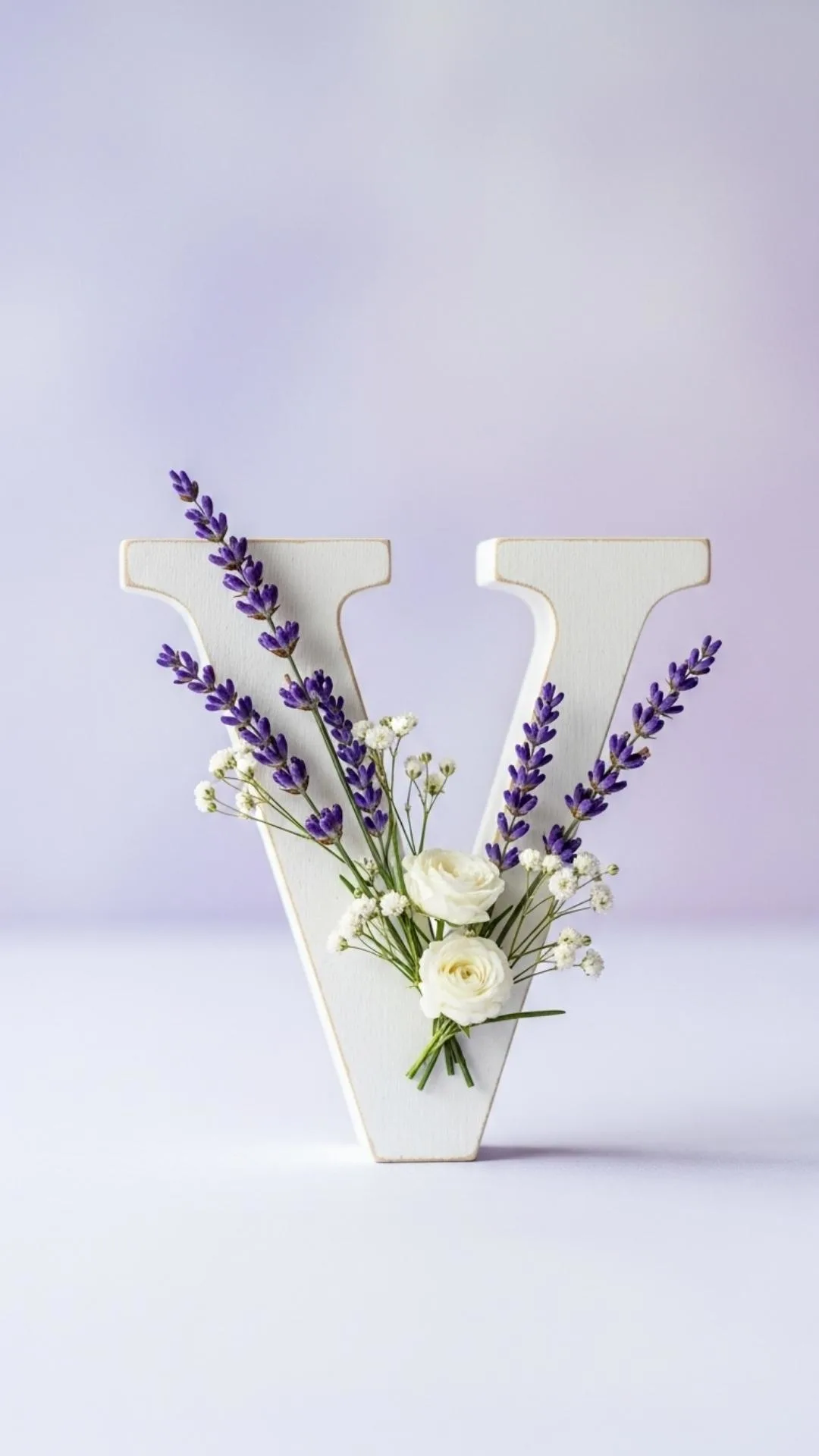 A 4K aesthetic 'V' letter image for DP, showing a clean white wooden 'V' adorned with delicate lavender flowers on a soft purple background. This 'cute V name dp' is perfect for a girl's WhatsApp or Instagram profile in India, reflecting a gentle, refined personality. Keywords: aesthetic V dp, V letter flower dp, V letter images for dp girl, cute V wallpaper 4K, V alphabet lavender.