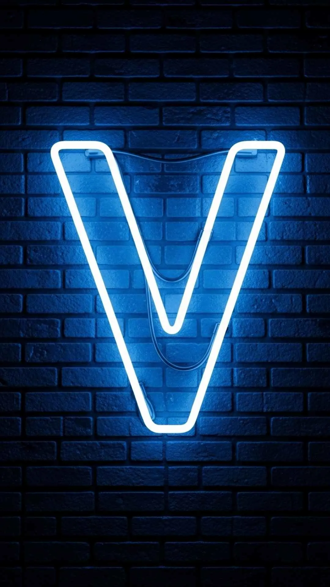 A modern 4K 'V' letter image for DP, showing a glowing 'electric blue' neon 'V' sign against a dark, wet brick wall. This 'stylish V name dp' is perfect for a cool, tech-inspired WhatsApp or Instagram profile for boys and girls in India. Keywords: neon V letter dp, V name dp stylish, V letter wallpaper aesthetic, cool V dp 4K, light V name.