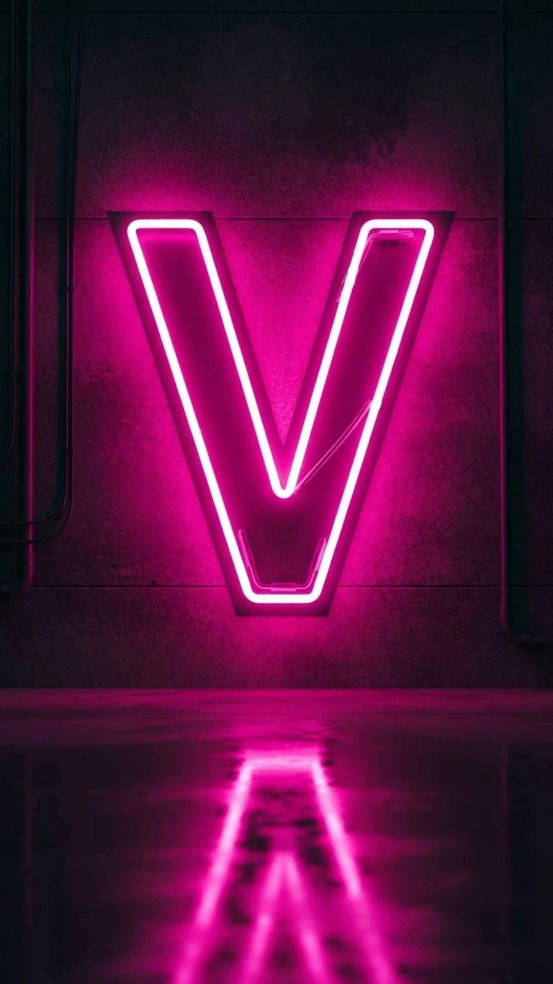 A modern 4K 'V' letter image for DP, showing a glowing 'hot fuchsia' (pink) neon 'V' sign against a dark, gritty urban wall. This 'stylish V name dp' is perfect for a cool, edgy WhatsApp or Instagram profile for girls or boys in India. Keywords: neon V letter dp, V name dp stylish, pink V name dp, V letter wallpaper aesthetic, cool V dp 4K, light V name.