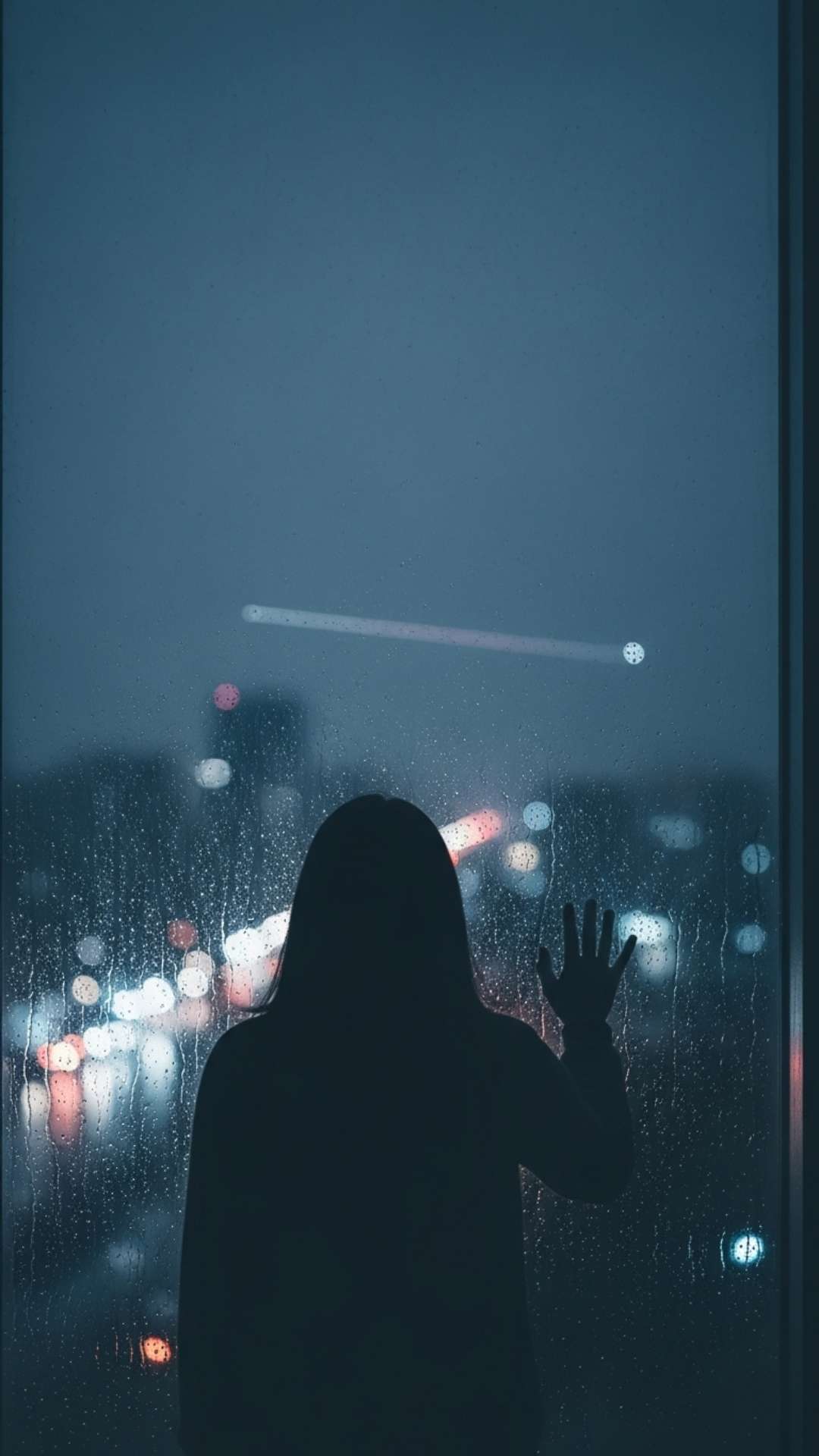 A moody vertical silhouette of a lonely person looking out a rainy window at a distant plane, depicting homesickness and the emotional struggle of living far away from family, ideal for a sad story update.