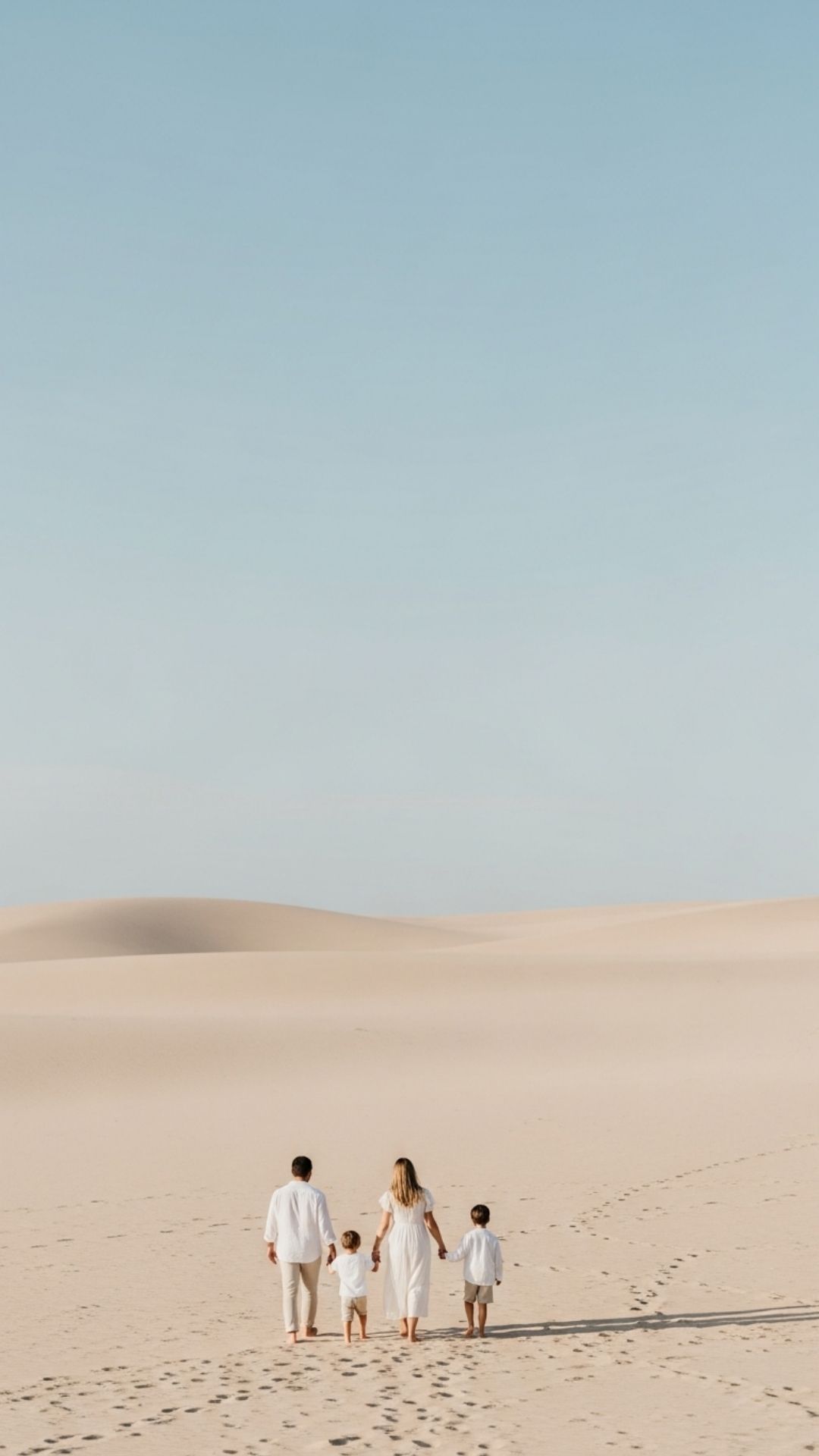 A vertical minimalist family wallpaper featuring small figures walking on a beach with vast negative space, offering a clean and sophisticated aesthetic background for Instagram Stories or DPs.